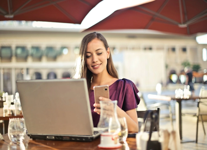 woman working on phone and laptop